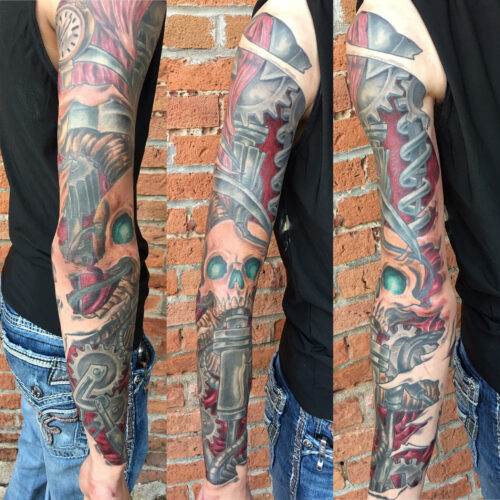 Full sleeve skull and gear tattoo by Rob Foster