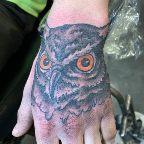 owl tattoo on top of hand  by Rob Foster at Cactus Tattoo in Mankato